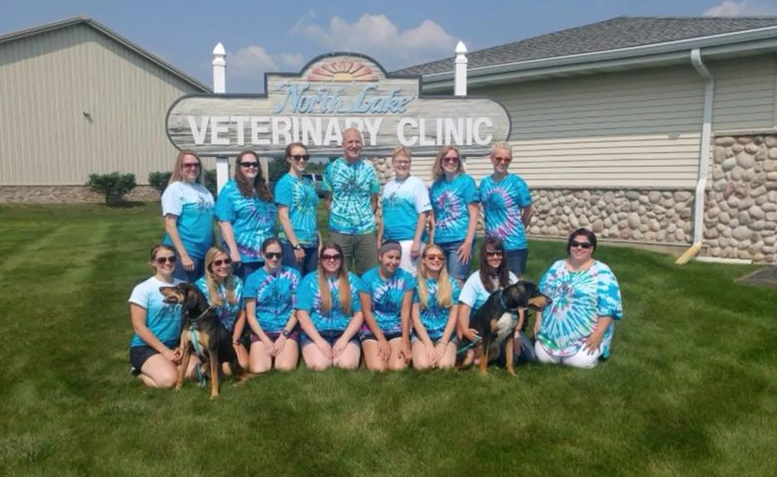 North Lake Veterinary Clinic's group staff photo outside of their building in front of their sign. 